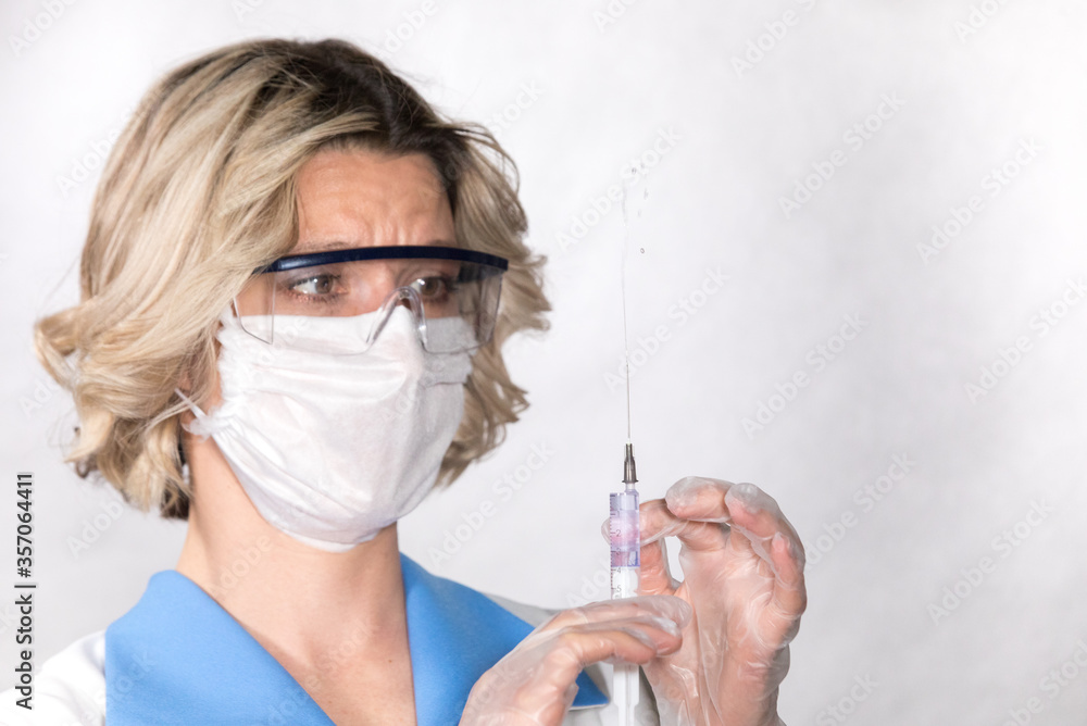 nurse with a syringe in her hands. she is getting ready to give an injection to the patient. nurse with a syringe in her hands. she is getting ready to give an injection to the patient.