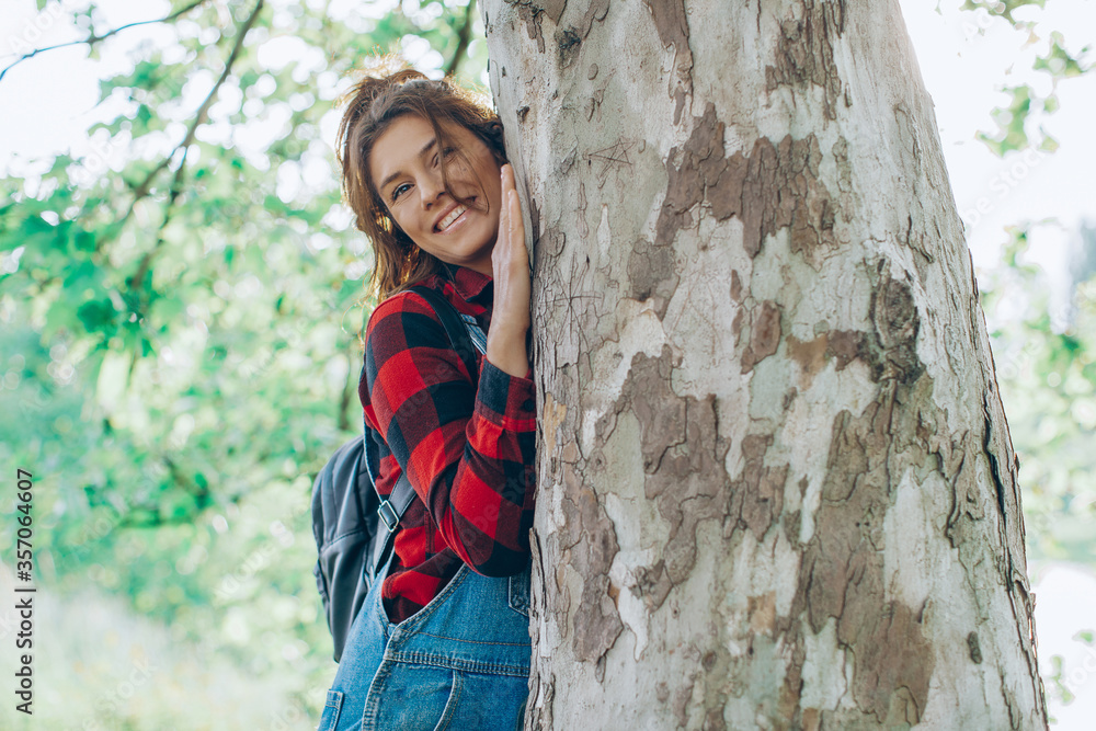 Contented young woman hugging a large tree Contented young woman hugging a large tree