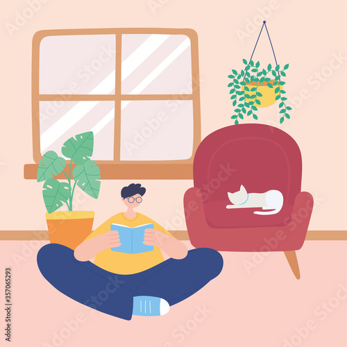 stay at home, young man reading book with cat on chair in room, self isolation, activities in quarantine for coronavirus