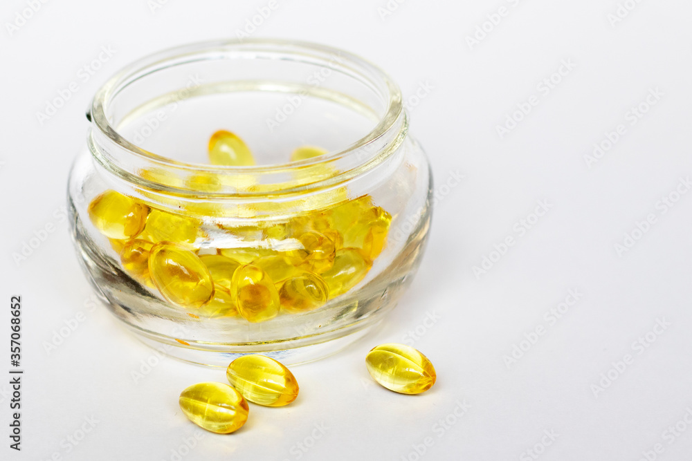 Glass jar of yellow medical pills on white background. Medical concept. Glass jar of yellow medical pills on white background. Medical concept.