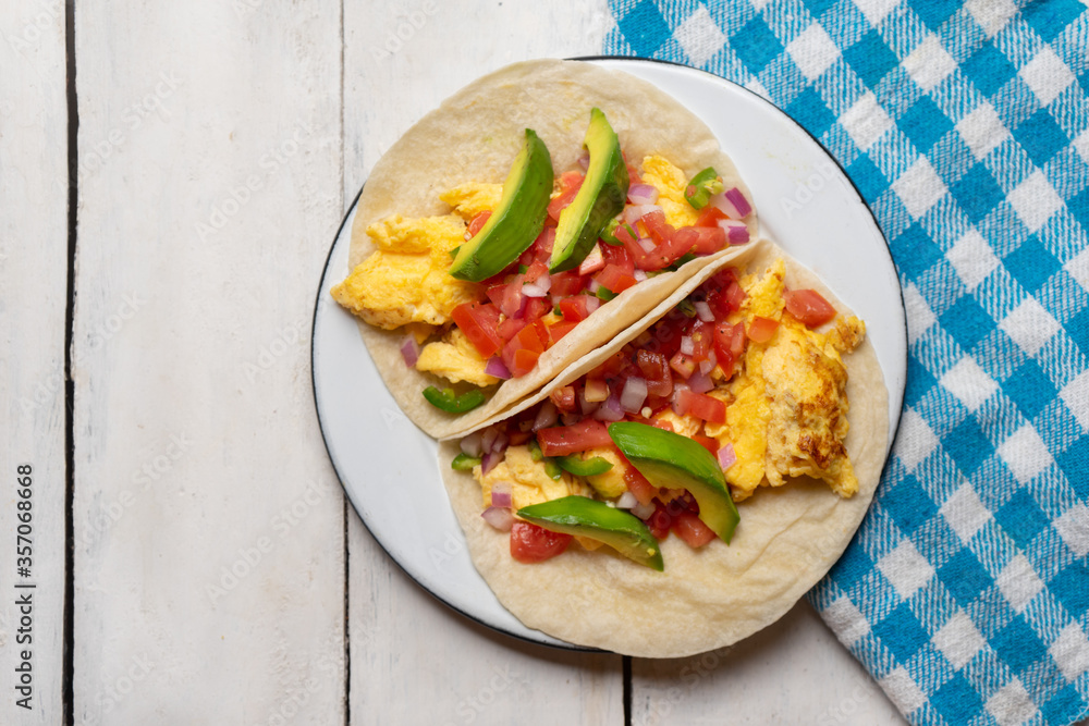Breakfast egg tacos with flour tortilla and fresh sauce on white background Breakfast egg tacos with flour tortilla and fresh sauce on white background