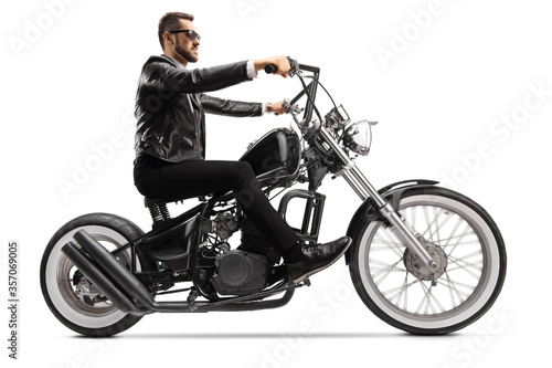 Profile shot of a biker on a custom chopper riding with sunglasses