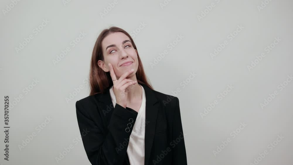 Hand on chin thinking about question, pensive expression. Doubt. Thoughtful face. Using that incredibly sharp business mind. Young attractive woman with brown hair in a light t-shirt, black jacket Hand on chin thinking about question, pensive expression. Doubt. Thoughtful face. Using that incredibly sharp business mind. Young attractive woman with brown hair in a light t-shirt, black jacket