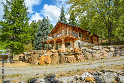 A picturesque rustic log home in the mountains surrounded by pine trees on a rocky hillside in Coeur d'Alene, Idaho. photo