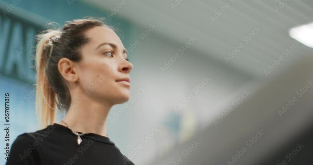 Young woman walking on a treadmill at gym.Warm up or cool down. Front view close shot, upper body detail. Woman training at fitness center. Woman exercising cardio workout Young woman walking on a treadmill at gym.Warm up or cool down. Front view close shot, upper body detail. Woman training at fitness center. Woman exercising cardio workout