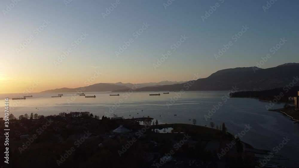 Aerial view of the bay during sunset with beautiful mountains and ships waiting Aerial view of the bay during sunset with beautiful mountains and ships waiting