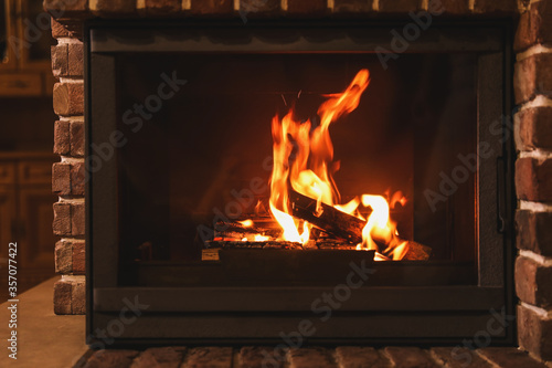 Fireplace with burning wood indoors. Winter vacation