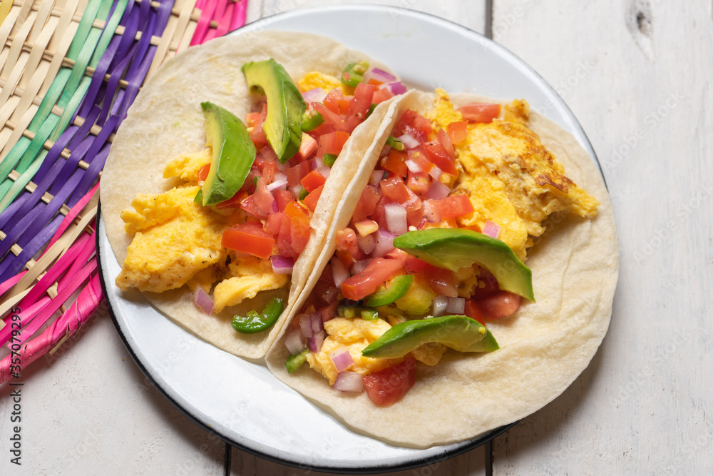 Breakfast egg tacos with flour tortilla and fresh sauce on white background Breakfast egg tacos with flour tortilla and fresh sauce on white background