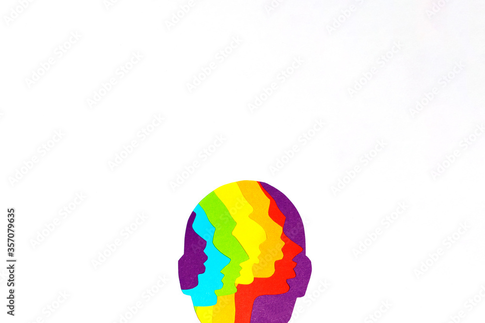 The upper half of the human face cut out of rainbow paper at the bottom of a white background. There is a place for text. The upper half of the human face cut out of rainbow paper at the bottom of a white background. There is a place for text.