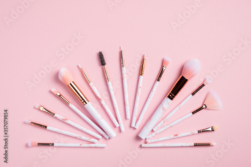 Foto Creative flat lay composition with makeup brushes on pink background
