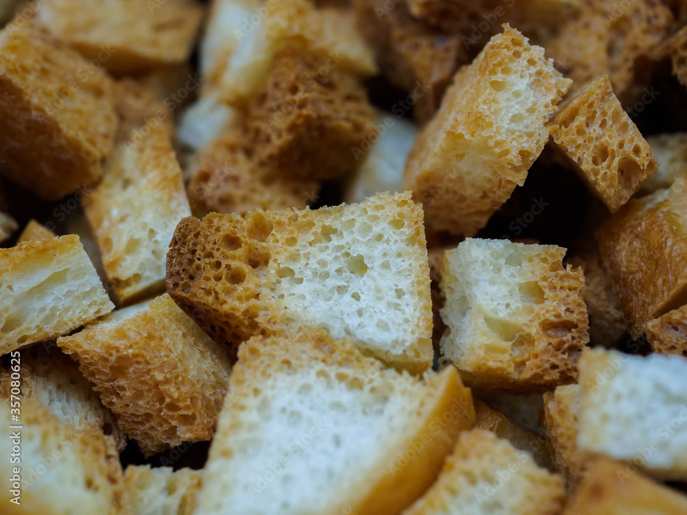 Selective focus on slices of fried white bread close-up. Tasty rosy croutons. Abstract food background. Selective focus on slices of fried white bread close-up. Tasty rosy croutons. Abstract food background.