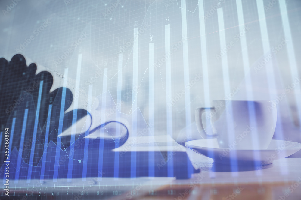 Double exposure of financial chart drawing and desktop with coffee and items on table background. Concept of forex market trading Double exposure of financial chart drawing and desktop with coffee and items on table background. Concept of forex market trading