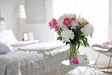 Beautiful blooming peonies on table in bedroom. Space for text