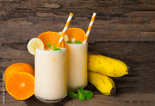 Banana and orange smoothies yellow colorful fruit juice milkshake blend beverage healthy high protein the taste yummy In glass,drink to lose weight drink episode on wooden background.