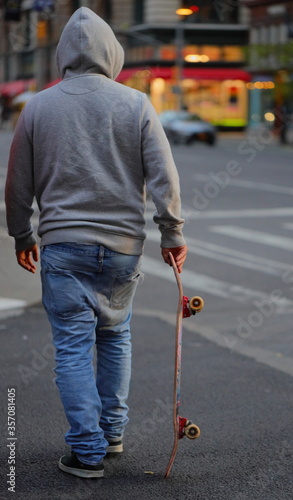Guy crossing street with his skateboard
