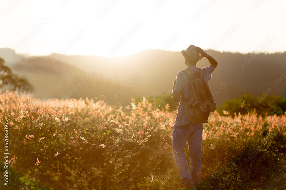 Fototapeta premium Backpacker. Young traveler with sunset in the background