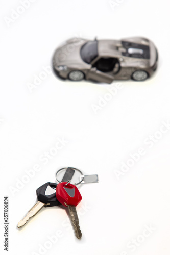 Car Loans and Credit Concepts. Blurred Car Along With bunch of Keys Against White Background.