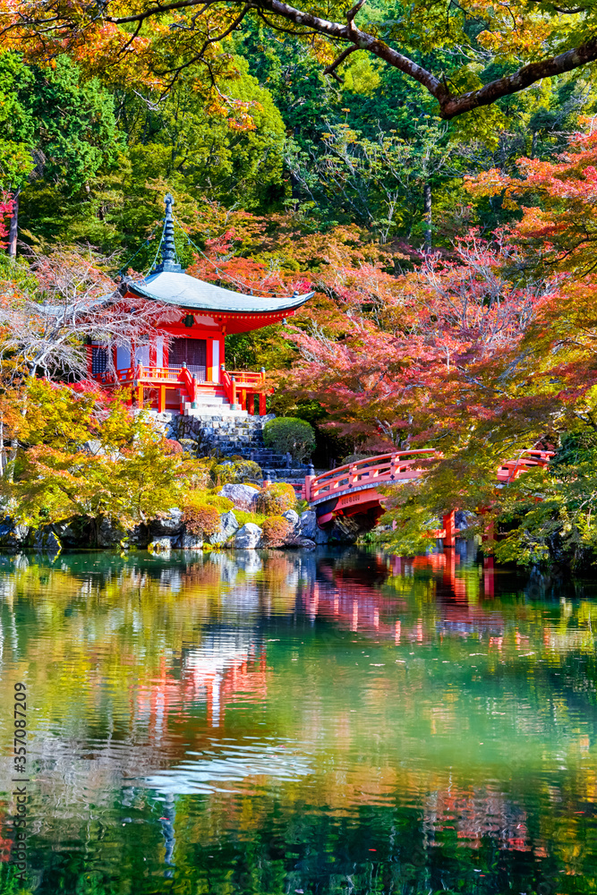 Naklejka premium Dziedzictwo japońskie. Spokojna słynna świątynia Daigo-ji podczas sezonu jesiennego pięknych czerwonych klonów w mieście Kioto w Japonii. Z odbiciami stawu w Foregorund.
