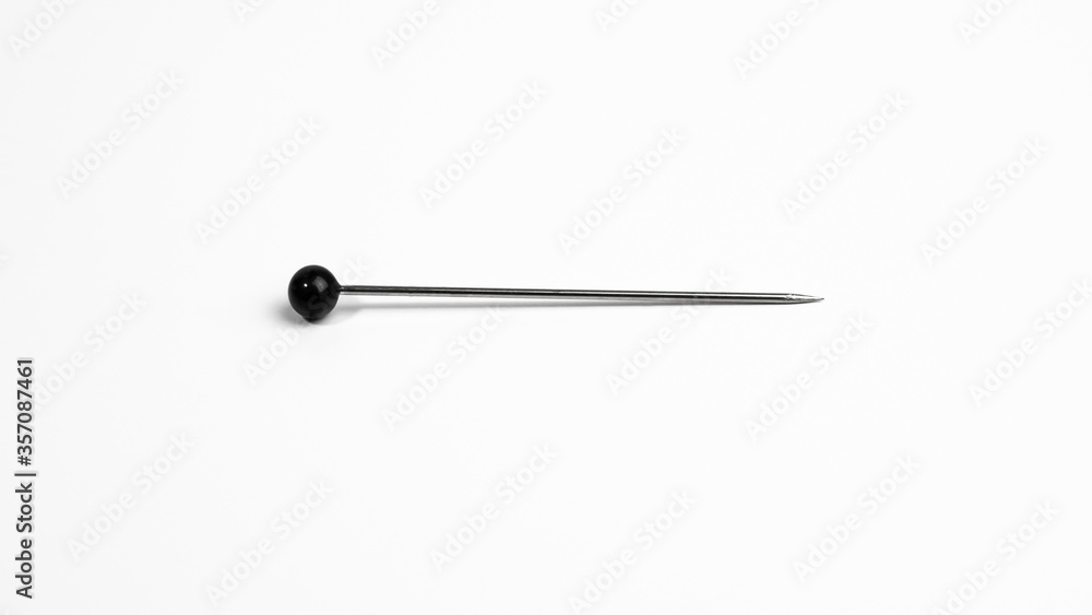 One pin with round black head on white background. One pin with round black head on white background.