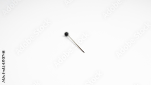 Sewing pin on white background. Selective focus with only the point in sharp focus.