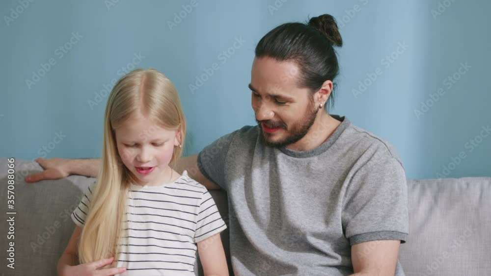 Young father is busy with his daughter, devoting time for her, enjoying his parenthood, reading favorite book together, Slow motion. Young father is busy with his daughter, devoting time for her, enjoying his parenthood, reading favorite book together, Slow motion.