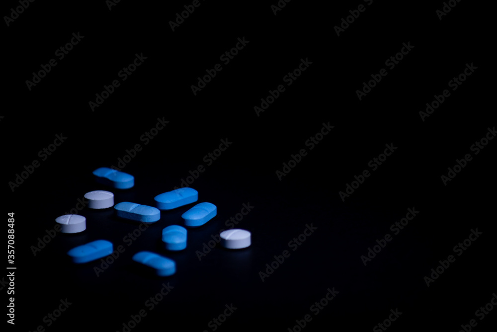 Colored pills on black background. illegal drug concept. Selective focus with copy space. Colored pills on black background. illegal drug concept. Selective focus with copy space.