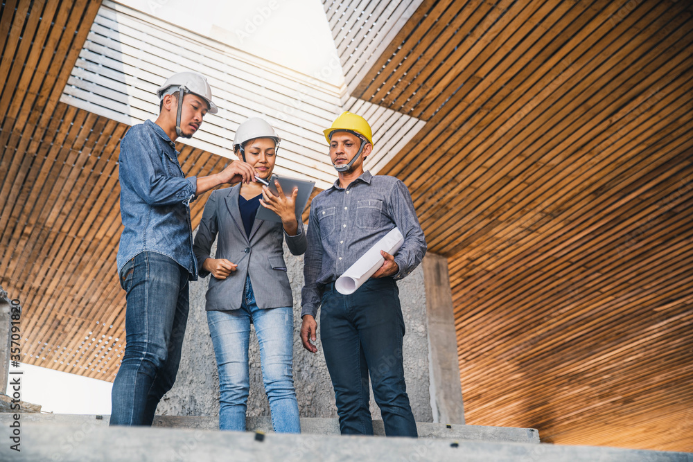 Engineer and business woman in hardhat posing on building site. civil engineer or architect with hardhat on construction site checking schedule on plan. Engineer and business woman in hardhat posing on building site. civil engineer or architect with hardhat on construction site checking schedule on plan.
