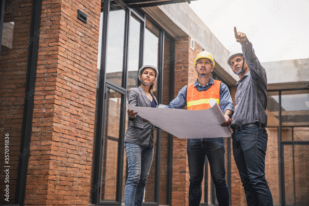 Obraz premium Engineer and business woman in hardhat posing on building site. civil engineer or architect with hardhat on construction site checking schedule on plan.