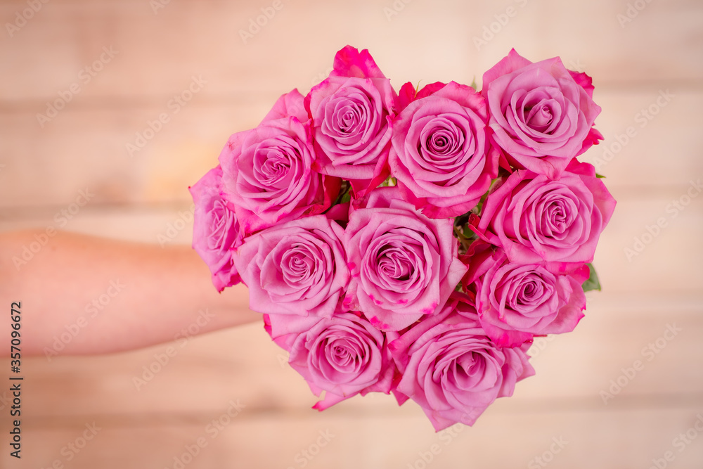 Women hand holding a bouquet of Moody Blues roses variety, studio shot. Women hand holding a bouquet of Moody Blues roses variety, studio shot.