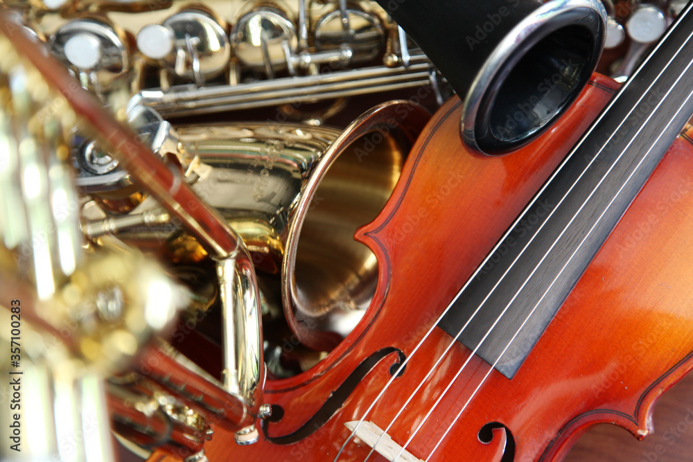 Naklejka premium Closeup detail of classical musical instruments; violin, saxaphone, and clarinet