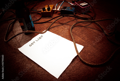 band setlist on stage with guitar effect pedals and cables