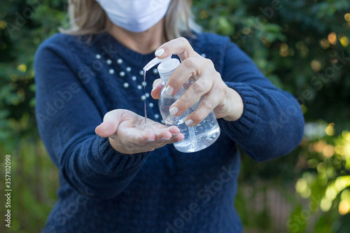 Brazilian woman cleaning her hands rubbing with sanitizer gel for corona virus and flu outbreak prevention. Hygiene to stop spread coronavirus. Closeup.