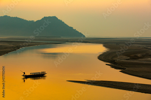 sunset on the river,silhouette of a man rowing a boat,Mayong, Brahmaputra river ,Assam,India photo