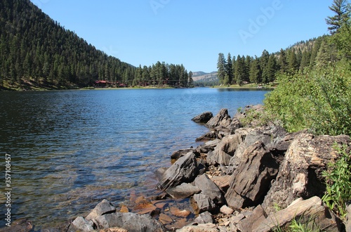 Blue lake, black rocks and green surroundings. 