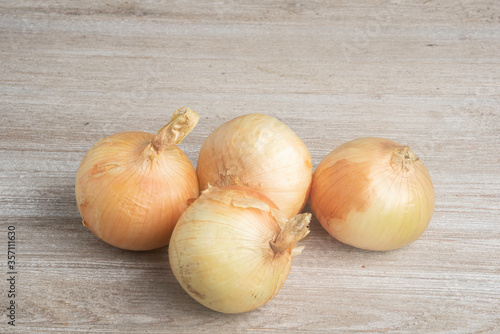 Four Sweet White Onions On A White Painted Panel Board