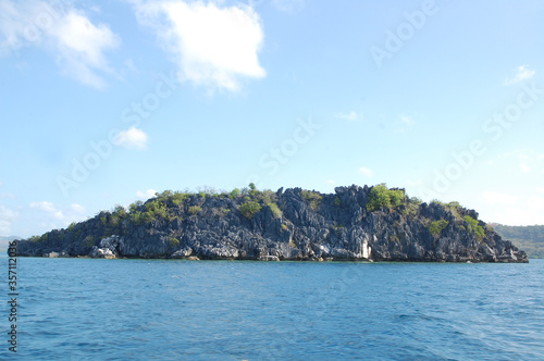 Limestone rock formation with sands, trees, and blue water sea