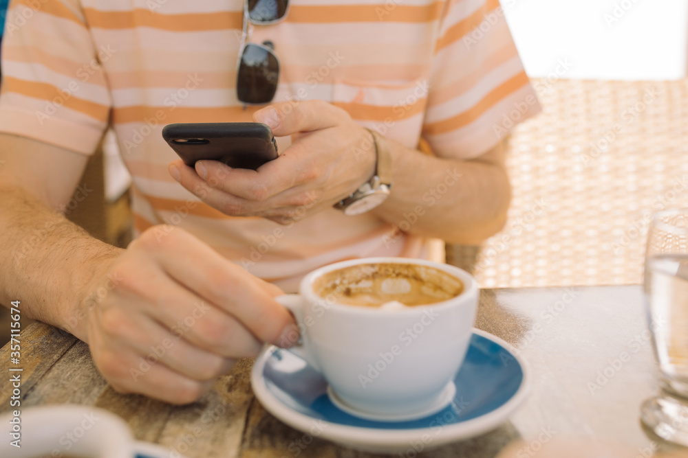 Close up of man taking photo of breakfast at cafe on sunny day. Close up of man taking photo of breakfast at cafe on sunny day.