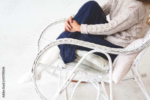 girl in a cozy vintage chair in a knitted light socks and sweater