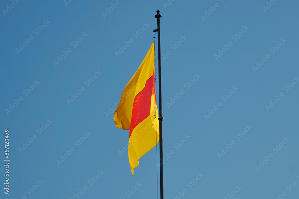 Close-up of red and yellow flag of Baden (Germany) with sky background Close-up of red and yellow flag of Baden (Germany) with sky background