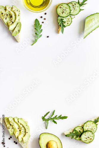 green toasts with avocado on white background from above copy space