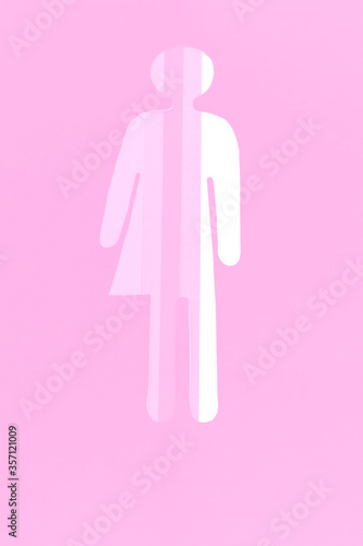 A gender-neutral silhouette is cut out of paper in all shades of pink. There is a place for text. The vertical photo of paper art for your design.