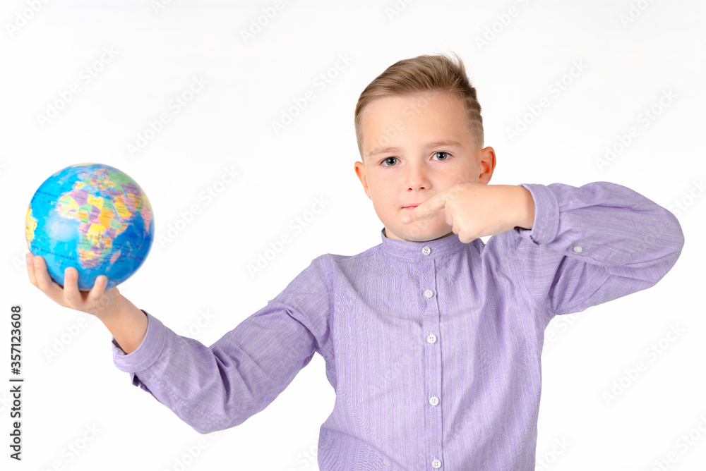 Playful young caucasian school boy holding a globe on white studio background.Boy is surprised shows at globe laughing Playful young caucasian school boy holding a globe on white studio background.Boy is surprised shows at globe laughing