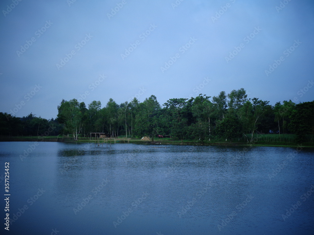 Landscape blue water and sky with green trees Landscape blue water and sky with green trees