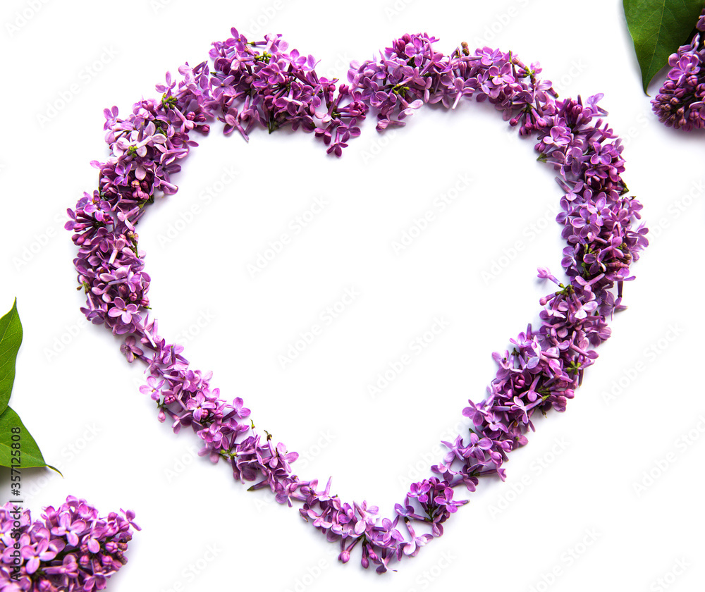 Frame of branches and flowers of lilac in the shape of a heart