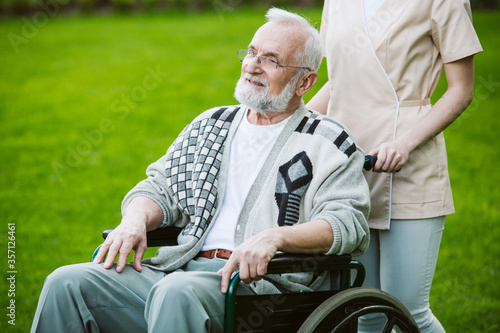 Senior man on the wheelchair in the garden of professional nursing home