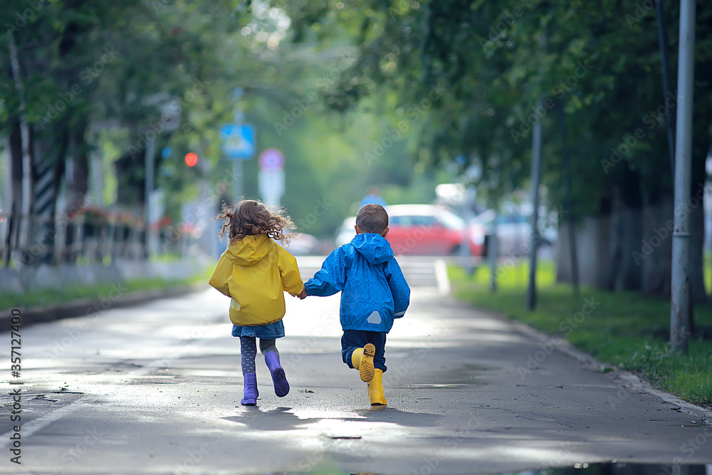 children run in raincoats / summer park, rain, walk brother and sister, children boy and girl