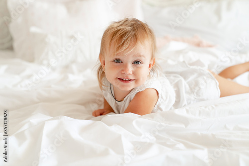 Wallpaper Mural little girl on bed in bedroom and laughs. happy childhood. Torontodigital.ca