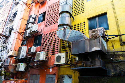 Homes in Asia hung with air conditioning. Hot climate. Narrow streets. The spirit of Asia.