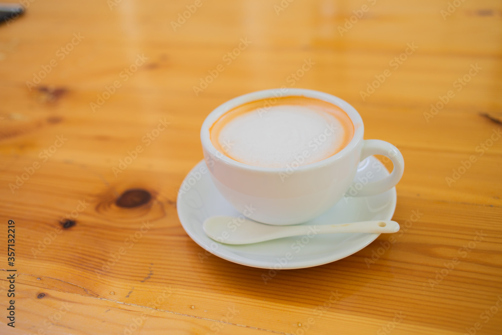 Hand Women put a Latte arts coffe hot coffee on wooden table.barista love art concept. Hand Women put a Latte arts coffe hot coffee on wooden table.barista love art concept.