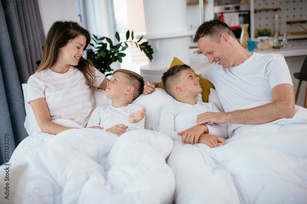Beautiful parents with kids enjoying at home. Young family watching movie on lap top. Beautiful parents with kids enjoying at home. Young family watching movie on lap top.